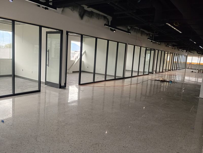A long run of floor to ceiling glass office partitions installed on polished concrete