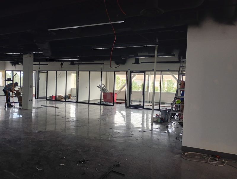 Glass office partitions being installed along an open floor plate