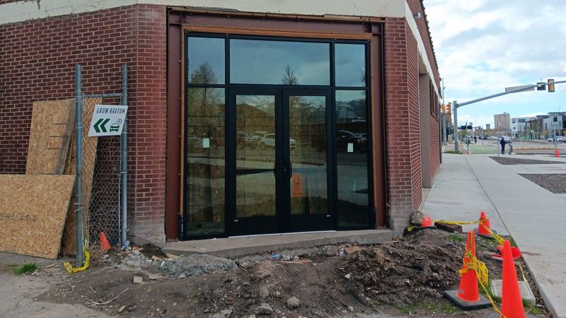 A completed commercial storefront with dark framing and double entrance doors