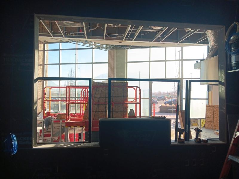 A glazed commercial storefront viewed from inside the unit during fit out