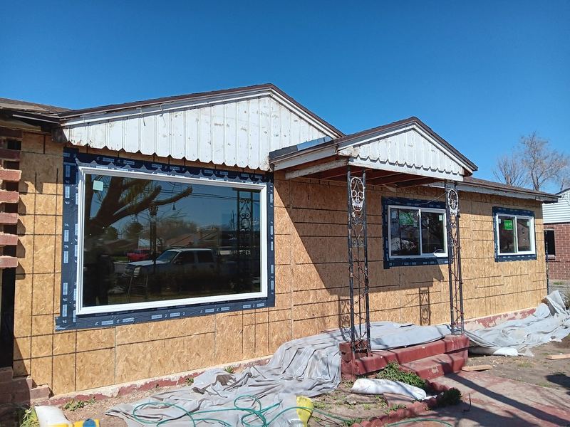 A large picture window installed into a home under renovation